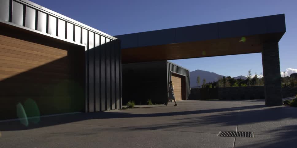 A woman approaches a large building on a sunny day