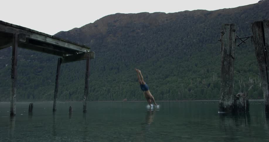 A man dives off the pier into the water