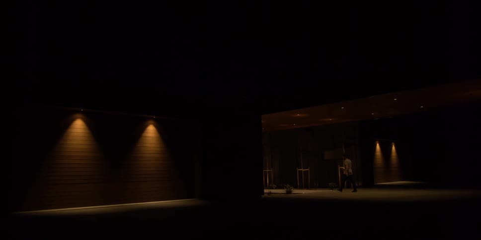 Person walking up to dimly lit building at night