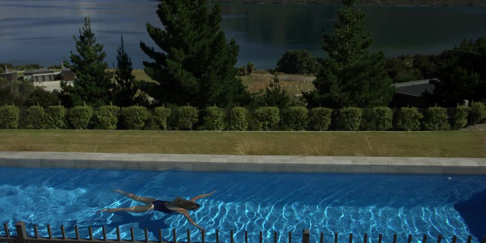 Person swimming in a long pool outside