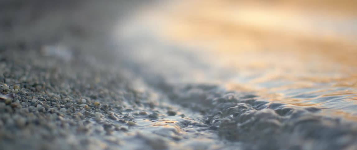 The water is rough and splashing against the shore