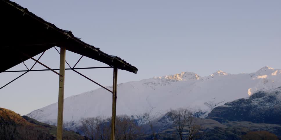 The roof hangs before a snow covered mountain
