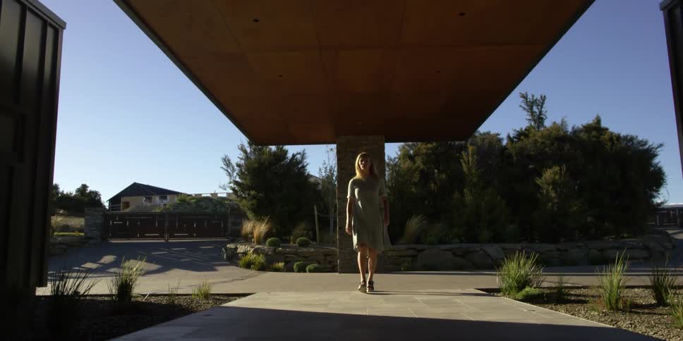 A woman is walking towards her home