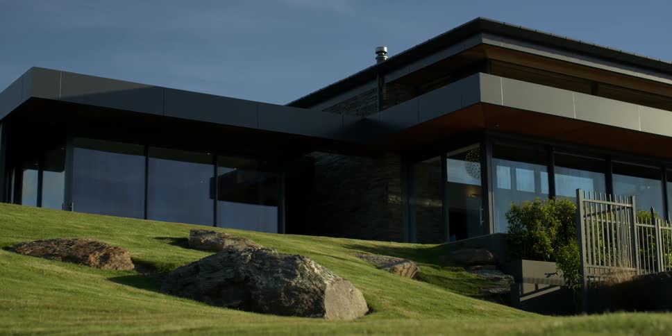 The green lawn leads up to a large home