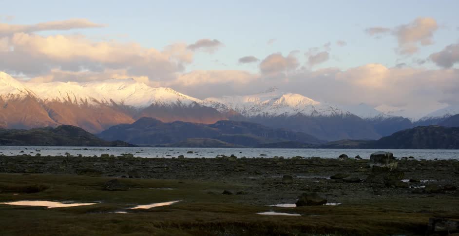 Lake flowing with mountains in the background