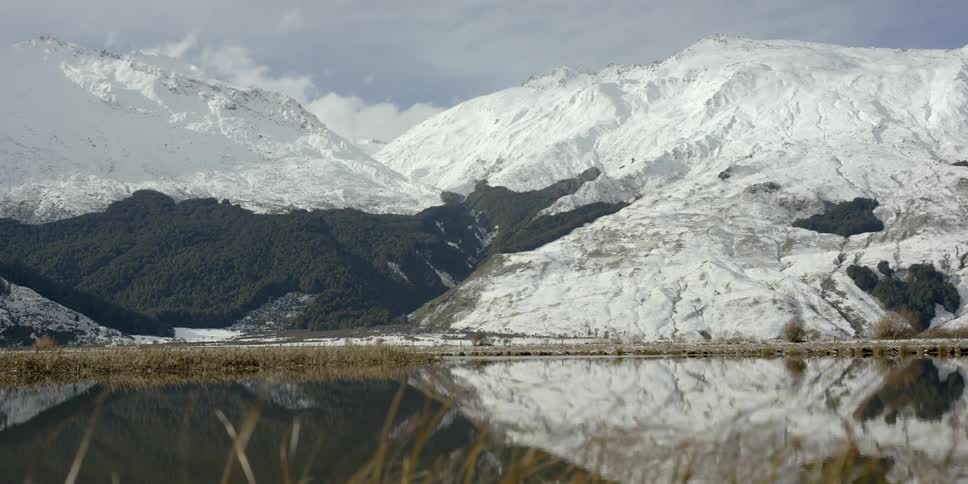 The lake is surrounded by grass before the mountain