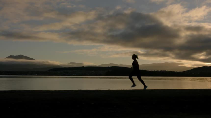 A woman is running near the lake