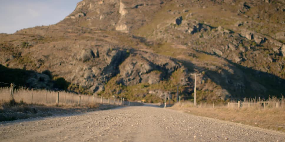 Dirt road leading to large rocky hills