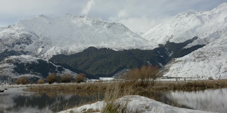 Snowy mountains surround a calm lake