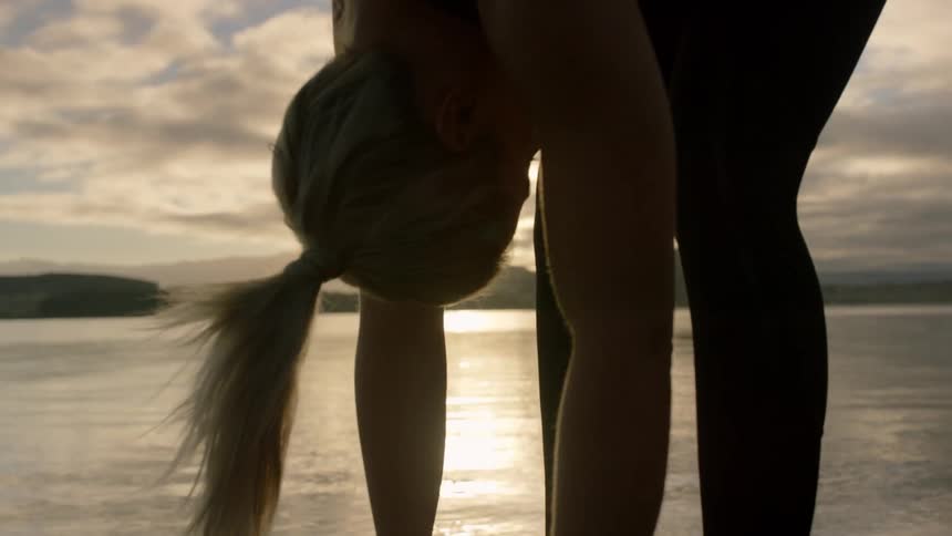 A woman is stretching leaning straight forward