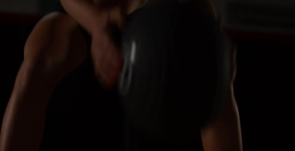 A woman slams a heavy ball on the ground