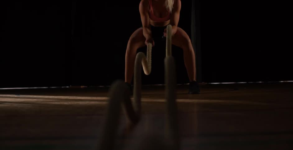 A woman pulls ropes fast