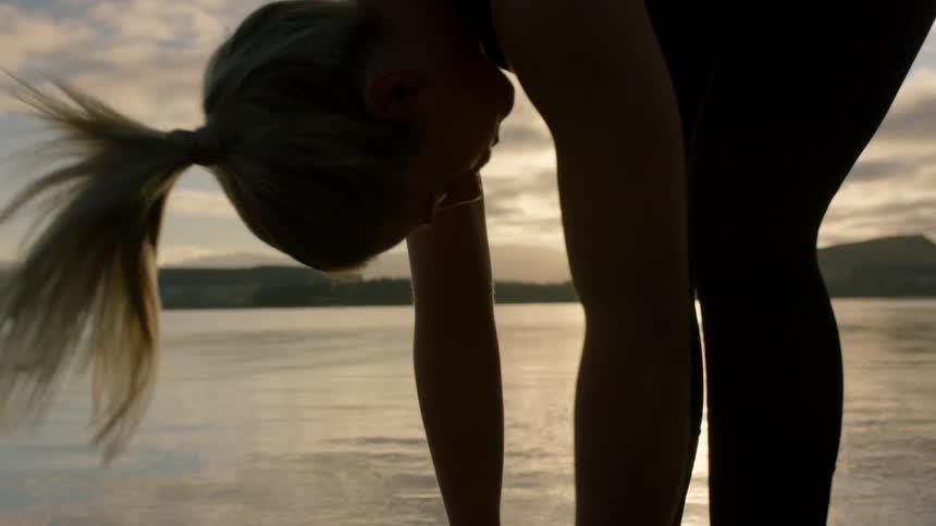 A woman leans forward near the water
