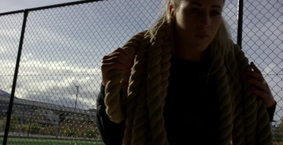 A woman is carrying many ropes on her shoulders