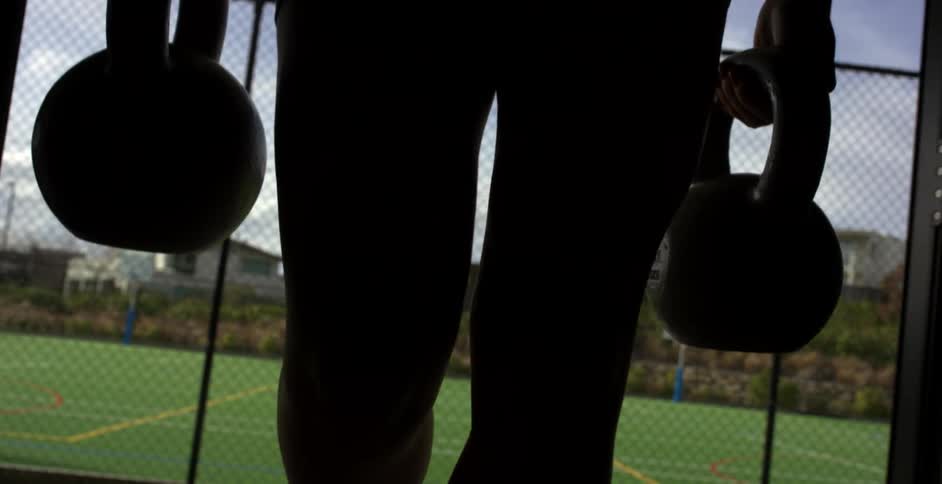 Person carrying two kettlebells