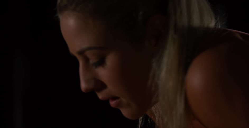 A woman smiles and looks down