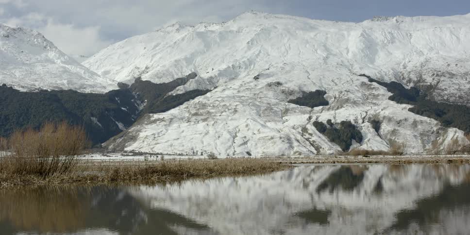 Beyond the lake the mountain is covered with snow