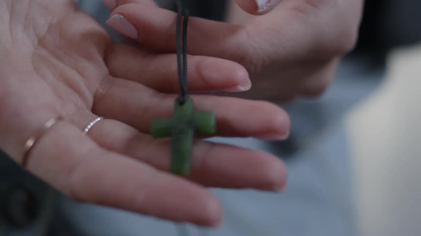 A woman traces her fingers across a green cross