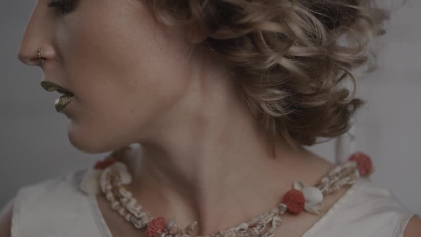 A woman is wearing gold lipstick