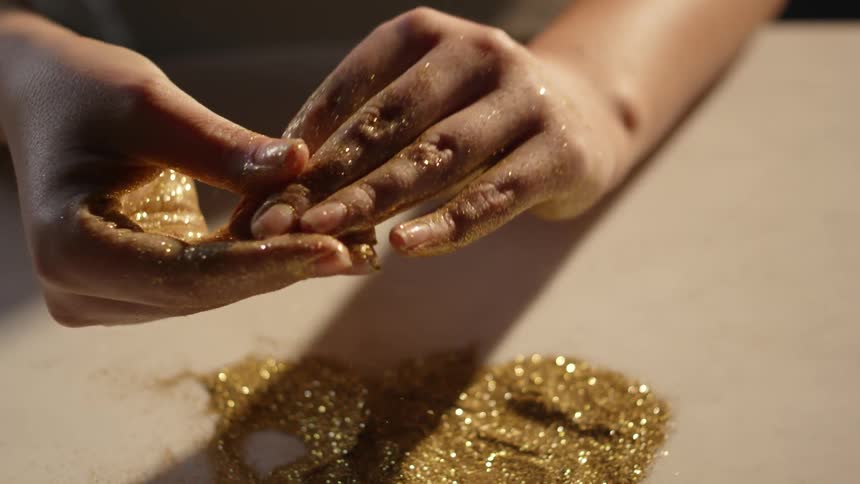 A person is rubbing glitter over their hands