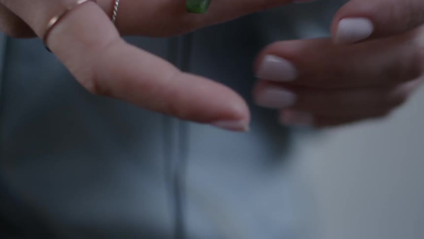 A woman examines a cross in her hand