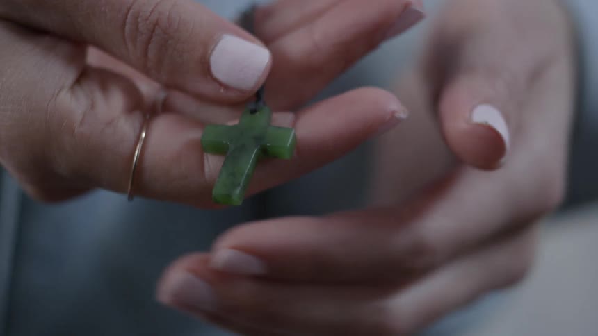A person holds a green cross