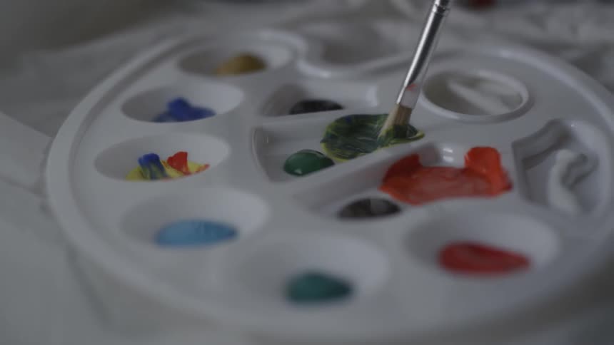 Person swirls paint with a small brush