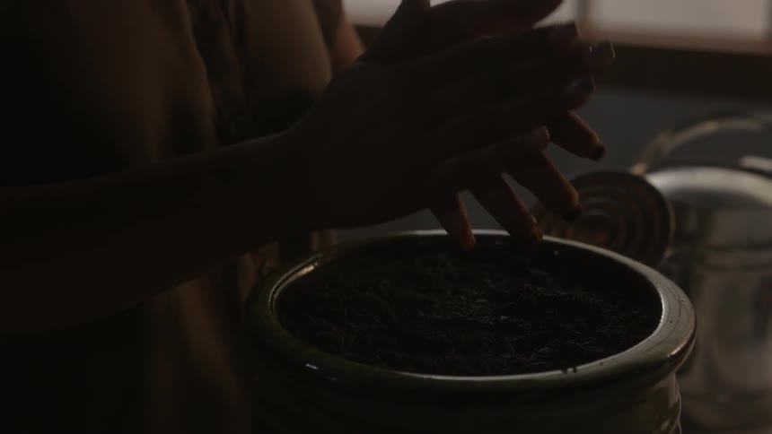 A woman is planting something in a pot