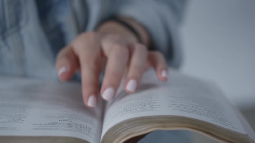 A woman follows lines of text with her hand