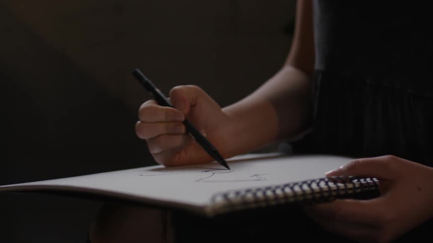 A person is writing in a notebook