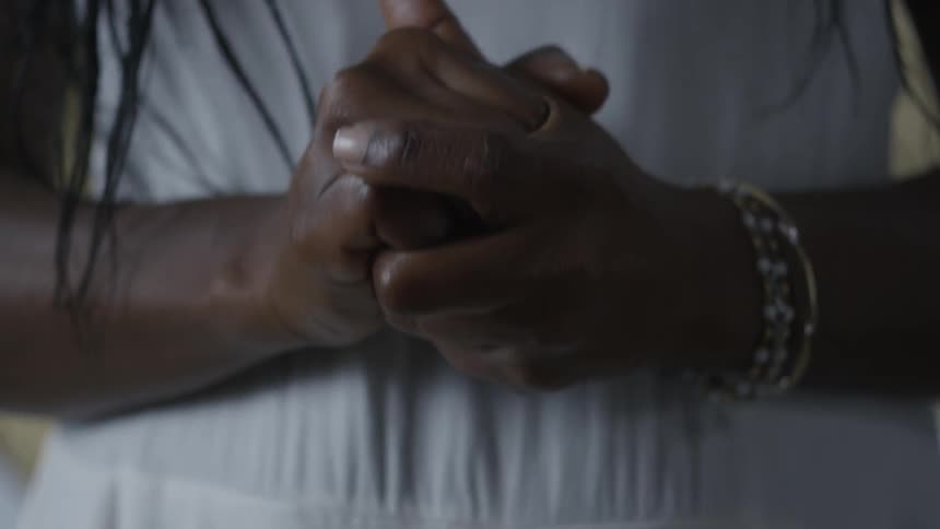 A person rubs their hands together and clasps them