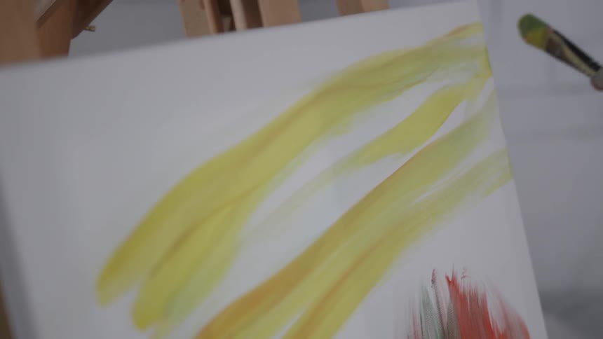 A woman applies paint to a canvas