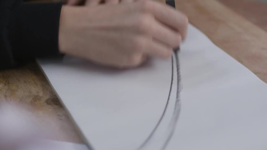 A person is drawing with charcoal