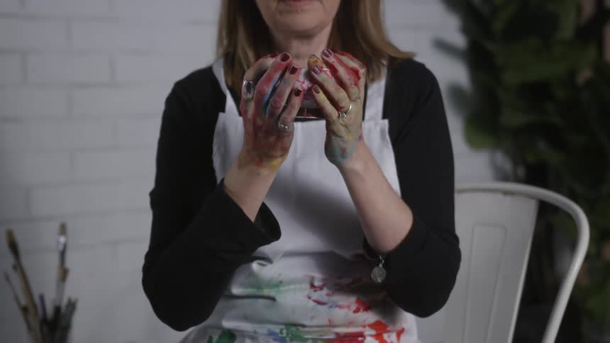 A woman holds a cup in her hands