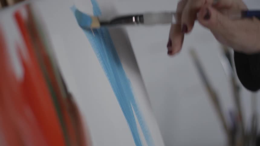 A woman paints on a canvas