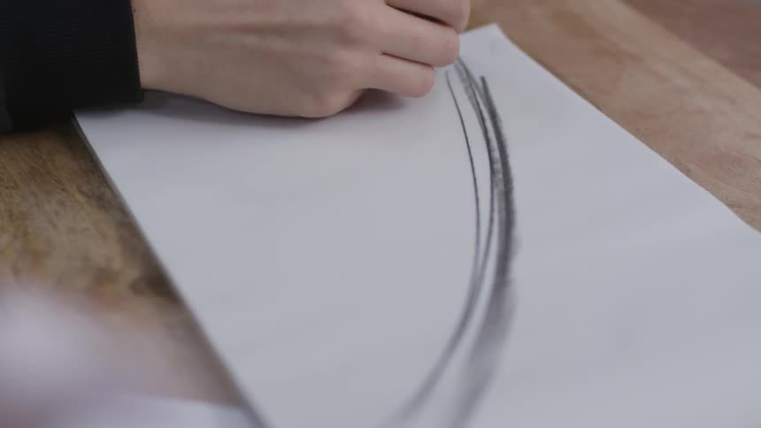 A woman draws a curved black line