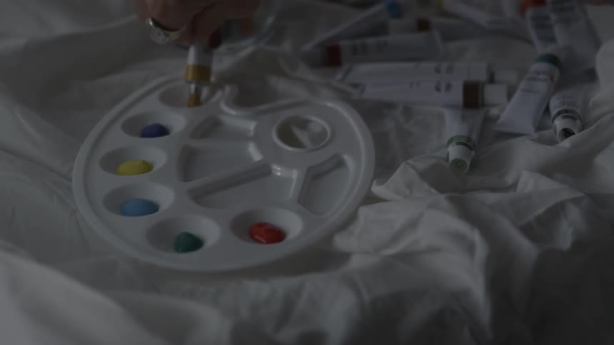 Paint is poured into the cups in the palette
