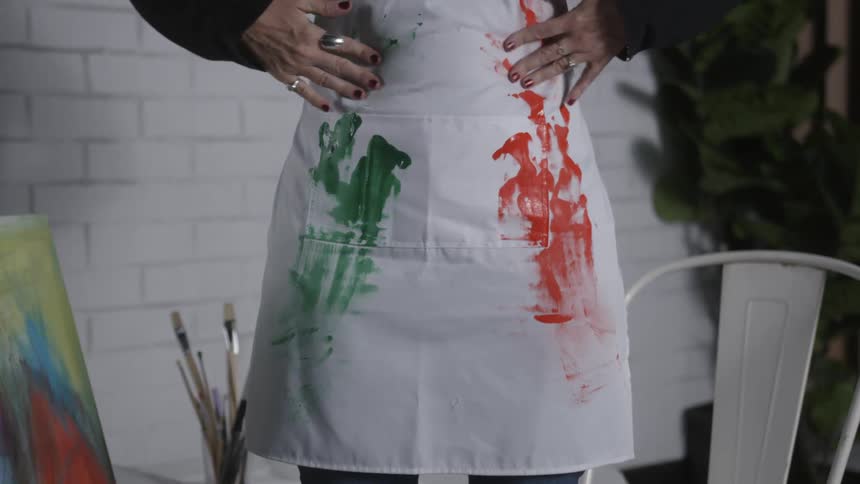 A woman wipes her hands straight down her apron