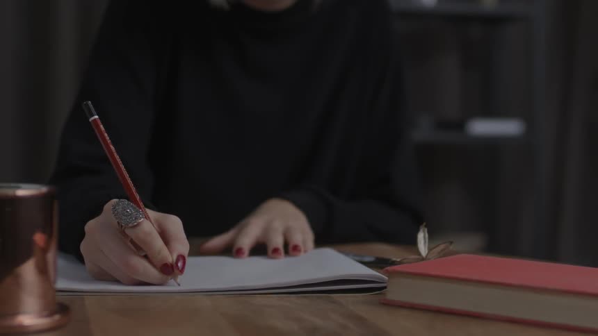 A woman writes in a notebook