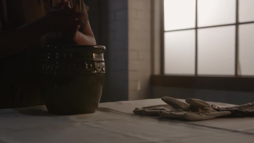 A woman rubs her hands above a pot