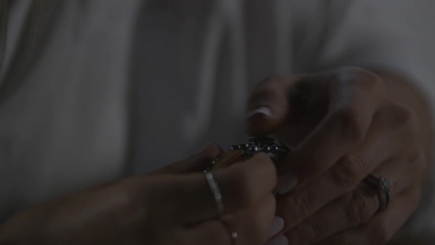 A woman sews a gem into a cloth