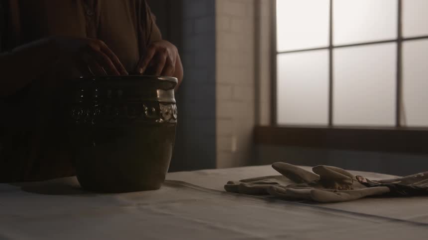 A woman plants seeds in a pot
