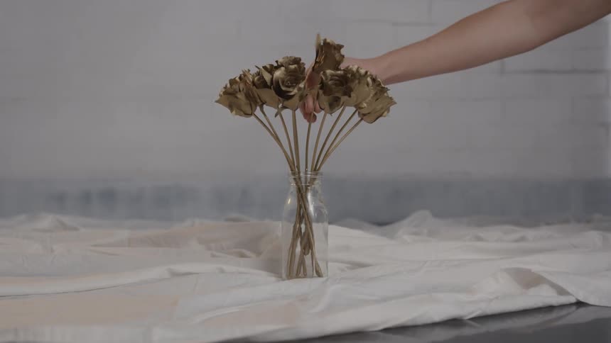 A vase is filled with gold flowers