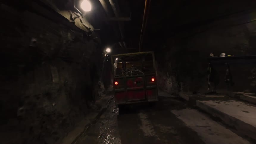 A truck moves slowly in the dark tunnel