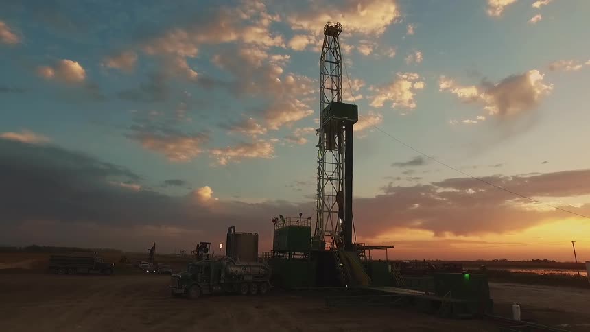The sun setting over a drilling rig