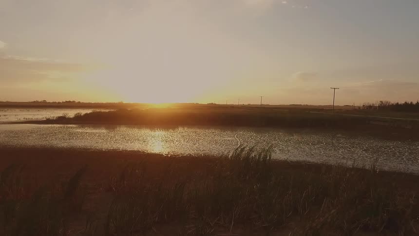 Sun rising over a lake and plains