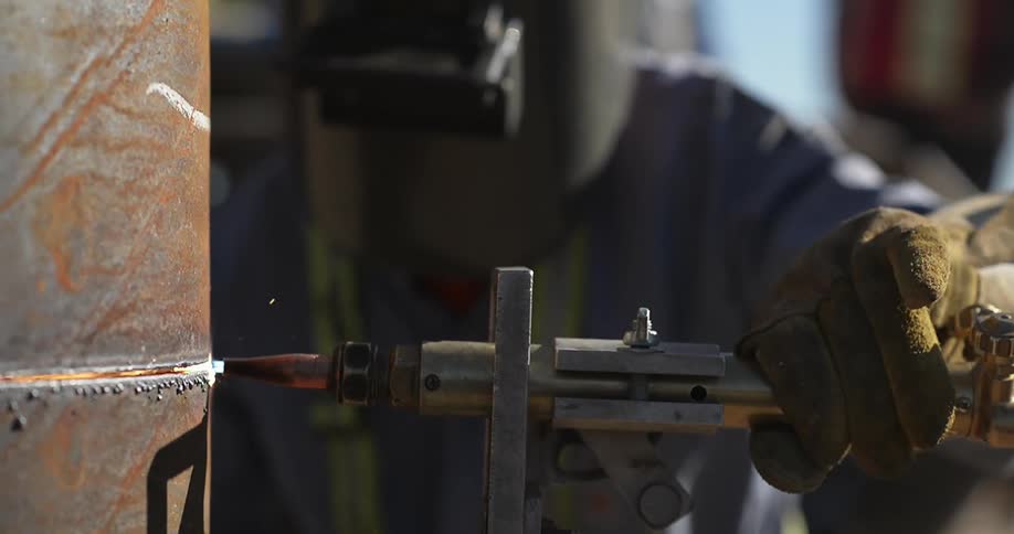 Person drills into a large metal pipe