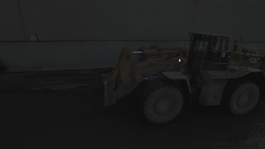 Tractor drives alongside a large building