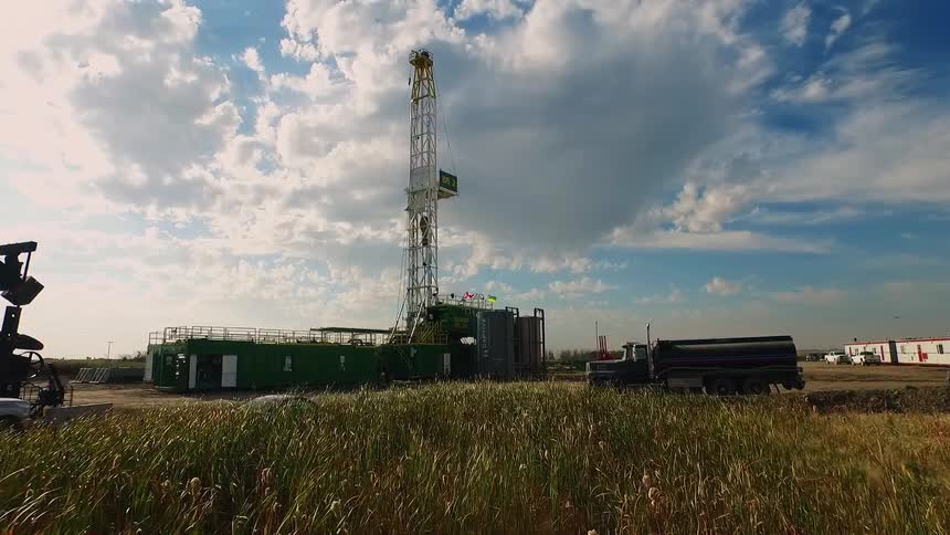 An oil rig is shown in a field on a cloudy day