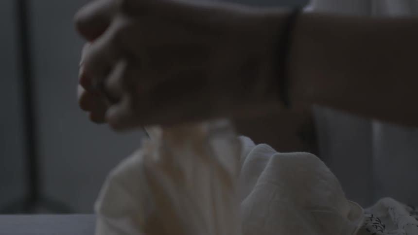 A woman handles a white blouse